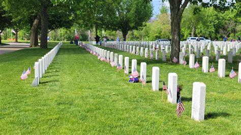 Volunteers place thousands of flags on veterans’ graves at National ...