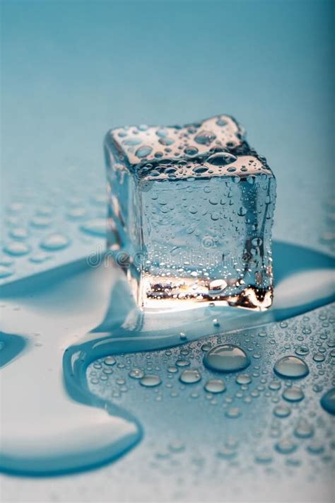 Ice Cube With Water Drops On A Blue Background. The Ice Is Melting ...