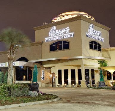 an exterior view of a restaurant with palm trees in the foreground and ...