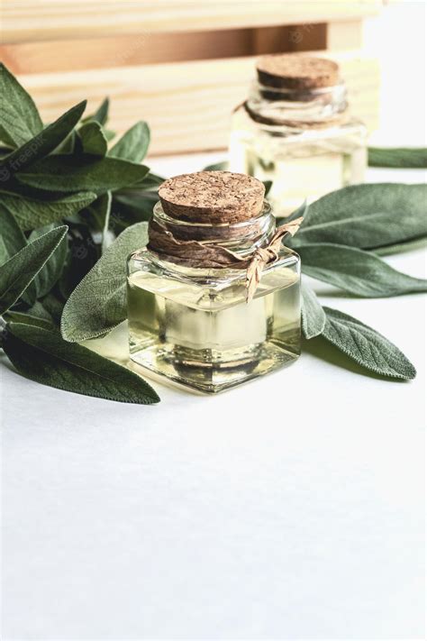 Premium Photo | Sage oil in bottles green sage leaf on white table copy ...