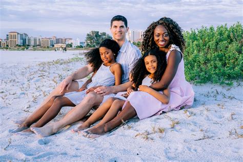 a family is sitting on the beach together