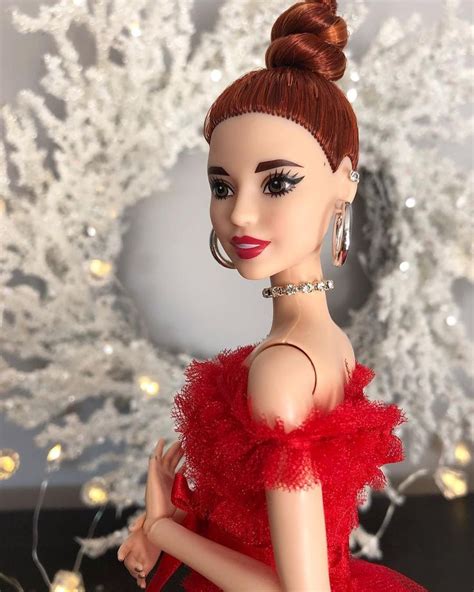 a barbie doll wearing a red dress in front of a christmas tree