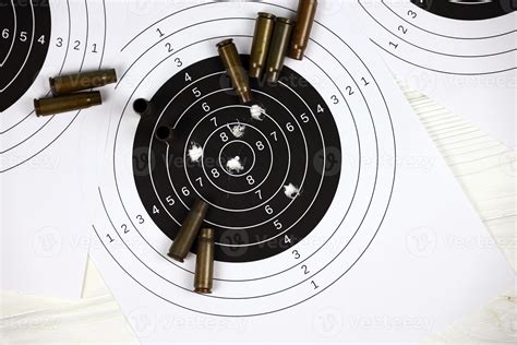 Many bullets on shooting targets on white table in shooting range polygon. Training for aiming ...