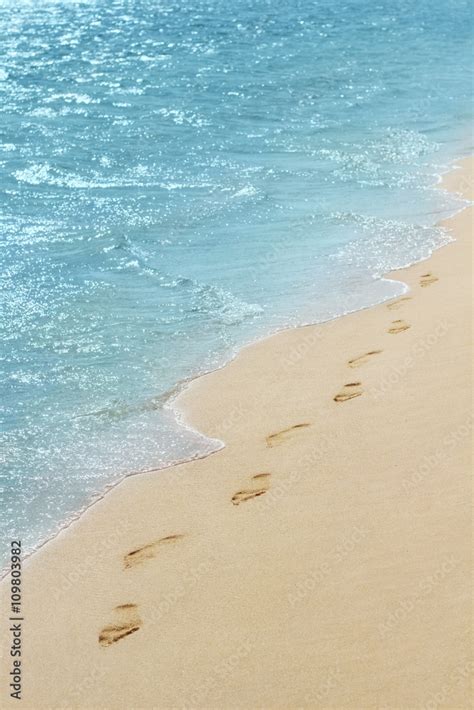 Foot prints on a sandy beach with selective focus Stock Photo | Adobe Stock