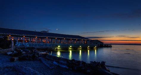 the pier is lit up at night with bright lights on it's windows and water