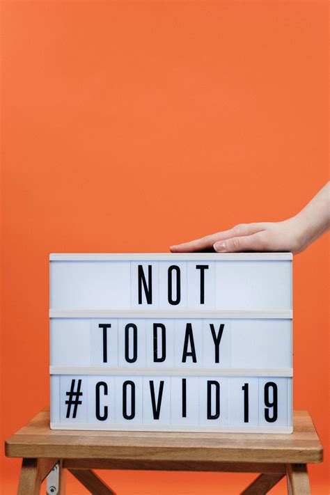 Person's Hand On A Covid19 Sign · Free Stock Photo