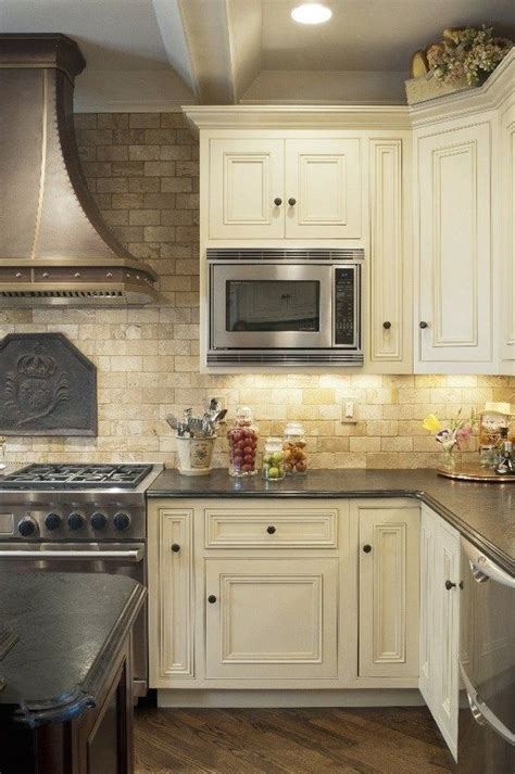 mediterranean kitchen design travertine tile backsplash white cabinets wood floo... | 1000 in ...