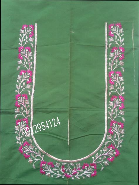 an embroidered garment with pink flowers and leaves on green fabric, in ...