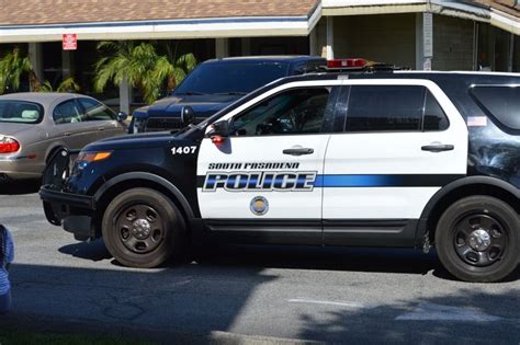 a police car parked in front of a building with palm trees on the other side