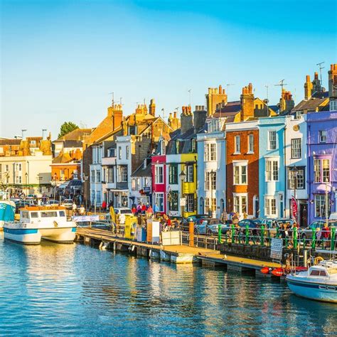 The beautifully colourful houses and fishing boats of Weymouth Harbour ...