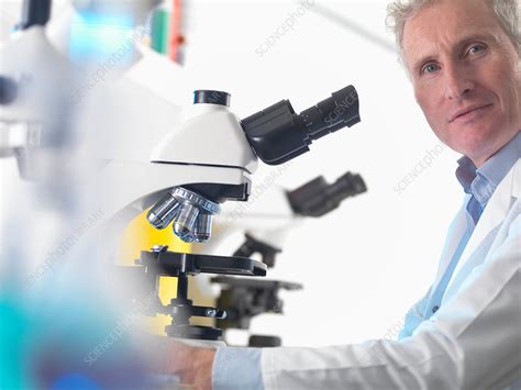 Scientist using microscope in lab - Stock Image - F018/9302 - Science Photo Library