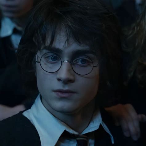 harry potter in glasses looking at the camera with other people behind ...