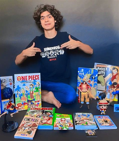 a man sitting on the floor surrounded by various cartoon books and dvds ...