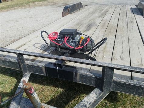 an engine on the back of a flatbed trailer with wires attached to it's sides