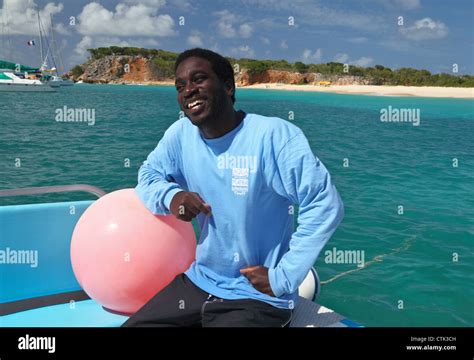 Captain relaxes while tour boat on day trip from St. Maarten is anchored off Tintamarre island ...