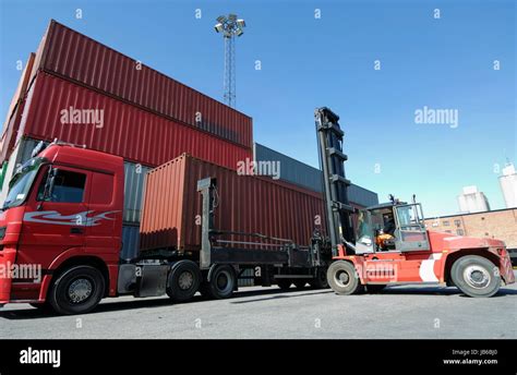 Forklift truck lifting shipping container Stock Photo - Alamy