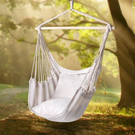 a white hammock chair hanging from a tree