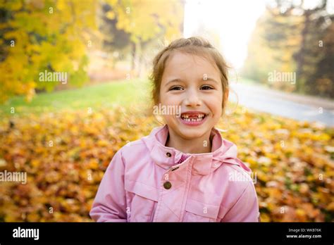 Portrait of Cute little girl with missing teeth playing with yellow ...