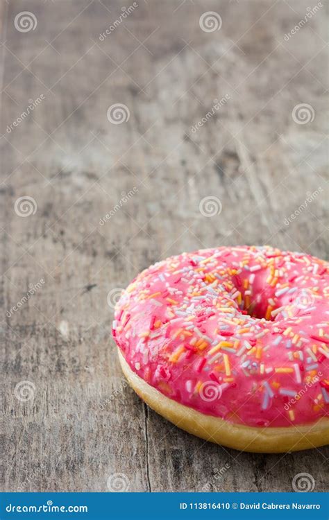Pink Frosted Donut with Colorful Sprinkles on Wood Stock Photo - Image of baked, frosting: 113816410