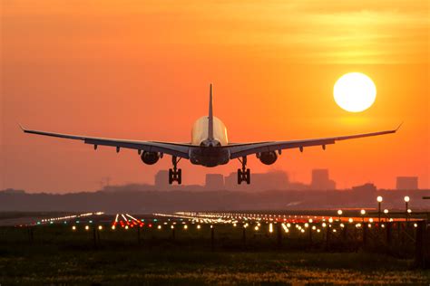 Passenger plane is landing during a wonderful sunrise. - Digital Firefly Marketing