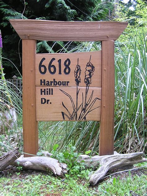 a wooden sign sitting on the side of a lush green field