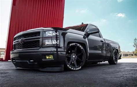 a black truck parked in front of a red building