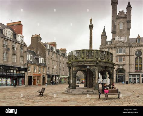 CASTLEGATE ABERDEEN SCOTLAND AND THE MARKET CROSS IN THE FORGROUND WITH ROW OF SHOPS AND HOUSES ...