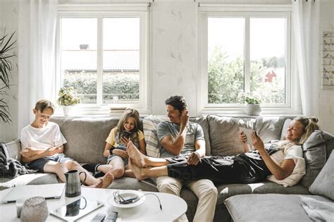 Happy family sitting on sofa in living room stock photo