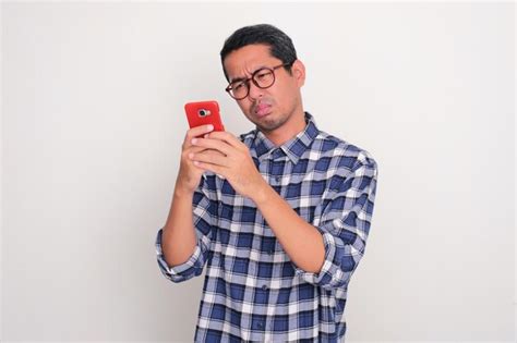 Premium Photo | Adult asian man looking to his phone with sad expression