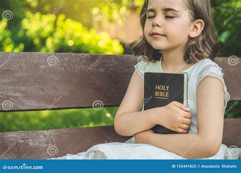 Reading the Holy Bible in Outdoors. Christian Girl Holds Bible in Her ...