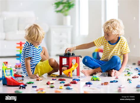 Kids play with toy cars in white room. Little boy playing with car and ...