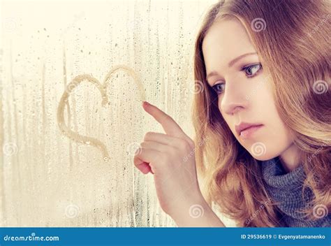 Sad Girl Draws A Heart On The Window In The Rain Royalty Free Stock Images - Image: 29536619