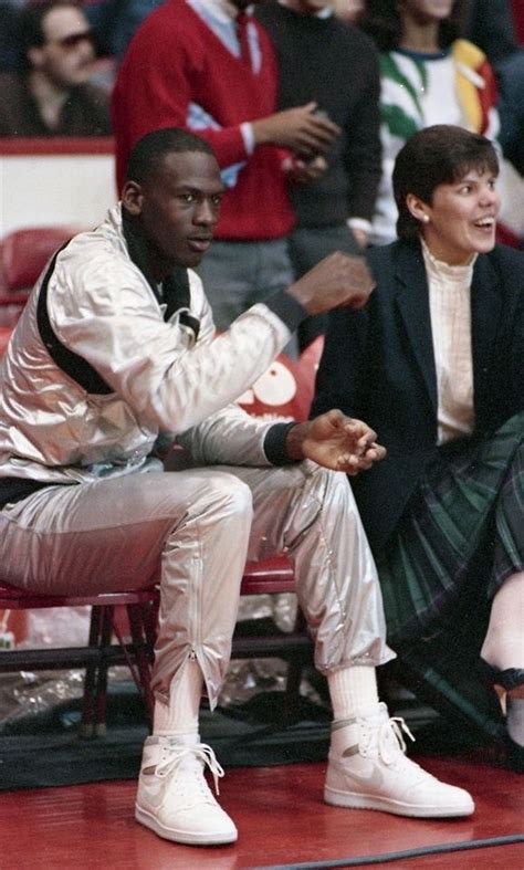 two basketball players sitting on the sidelines with their hands in ...