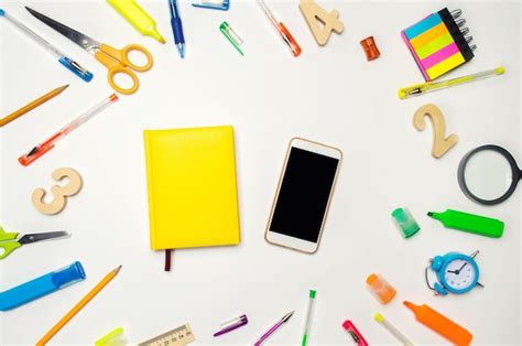 Premium Photo | Mobile phone and yellow notebook in the desk white background concept of education