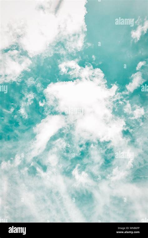 Beautiful white soft fluffy clouds on a cold green sky background Stock Photo - Alamy