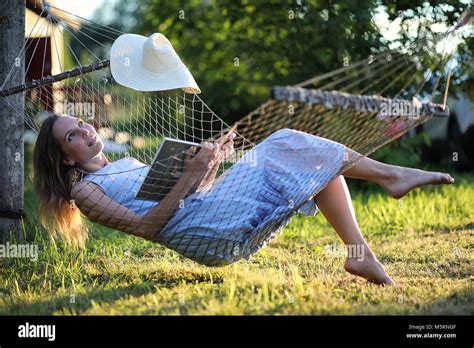 Beautiful young girl lying and reading a book Stock Photo - Alamy