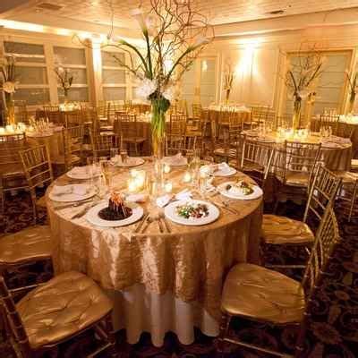 a banquet room set up with gold linens and white tablecloths for an ...