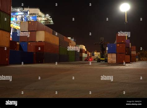 operation of container terminal at night. Unloading container ship at ...