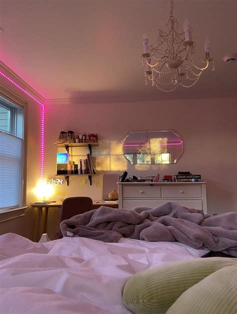 a bedroom with a chandelier and pink lights