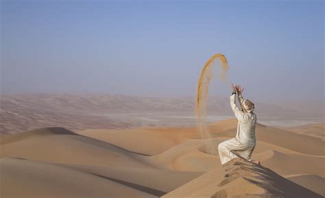 Man in kandura in a desert, throwing sand | Man in tradition… | Flickr