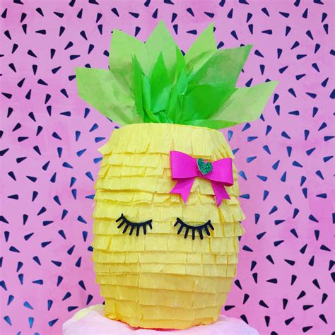 a pineapple made out of tissue paper with eyes and eyelashes on it's head