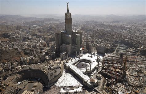 An aerial view shows the Mecca Clock Tower as Muslim pilgrims walking around the Kaaba in the ...