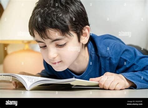 little boy reading book under a tent at home alone Stock Photo - Alamy