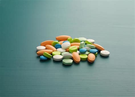 Many colorful pills on green background 8712765 Stock Photo at Vecteezy