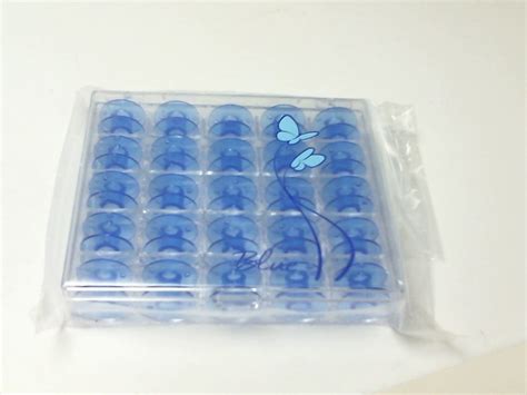 JANOME BOBBIN CASE W/25 BLUE BOBBINS. - 200277084