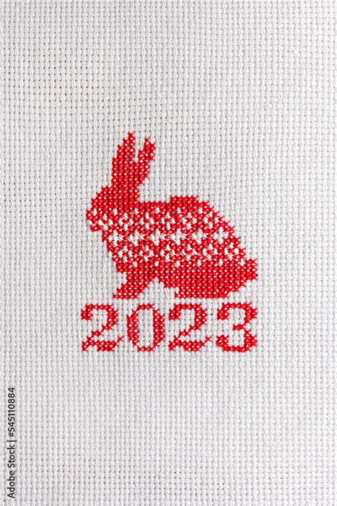 The symbol of 2023 is a rabbit embroidered with red threads on a white ...