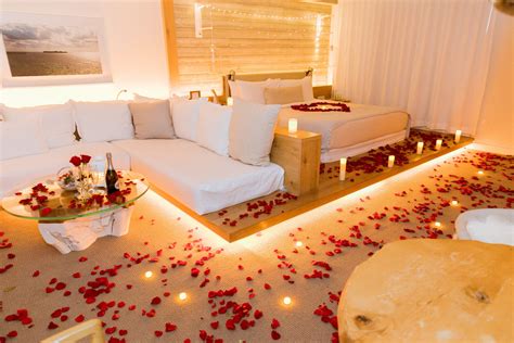 The romantic hotel room decoration in 1 Hotel (Miami). Real rose petals, candles and flowers ...