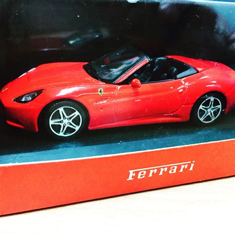 a red toy car in a box on a table