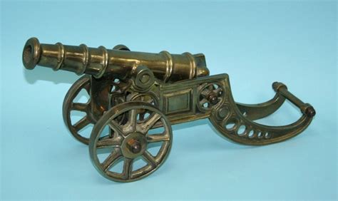 A miniature antique brass cannon resting on a - Nov 16, 2011 | Gallery Sixtyeight Auctions in Canada