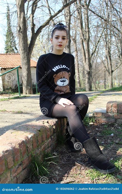 Teenage Girl is Sitting on a Brick Wall in the Park Stock Photo - Image of dress, wall: 183696062